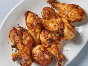 Baked chicken drumstick served in a white dish