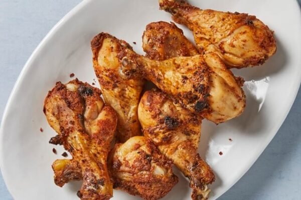 Baked chicken drumstick served in a white dish