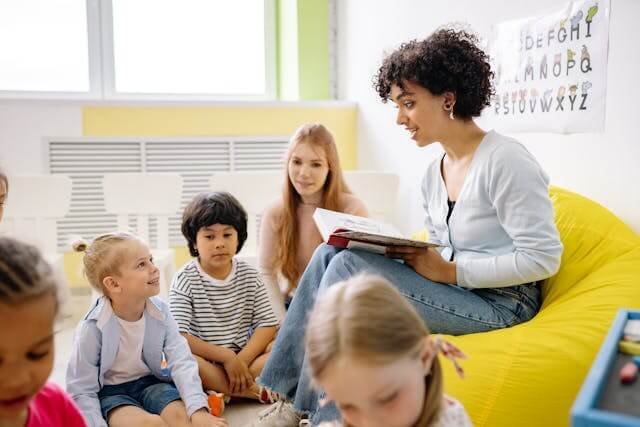 A woman reading a book to a group of children